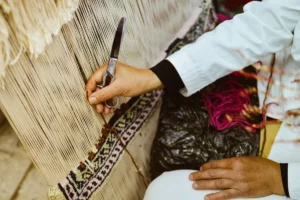 a person cutting a piece of fabric with a pair of scissors