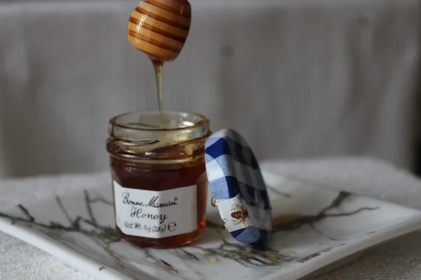 honey jar on white and blue checkered textile